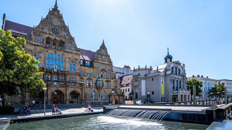 Fountain in the sunshine in front of the Old Town Hall and the theatre in Bielefeld
