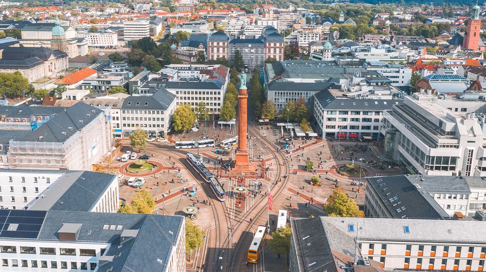 Blick von oben auf einen Platz in Darmstadt mit einer hohen Säule in der Mitte