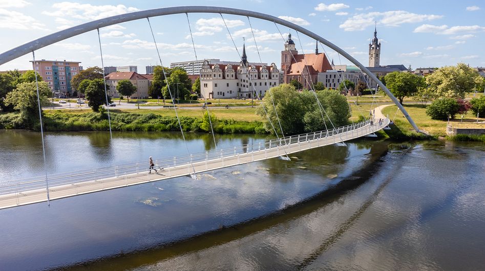 Tiergartenbrücke über die Mulde mit der Innenstadt Dessaus im Hintergrund