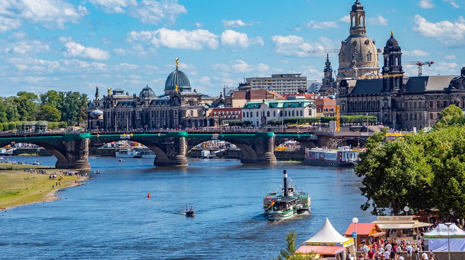 The river bank of the Elbe River in Dresden with the Augustus bridge and the Frauenkirche church in the background