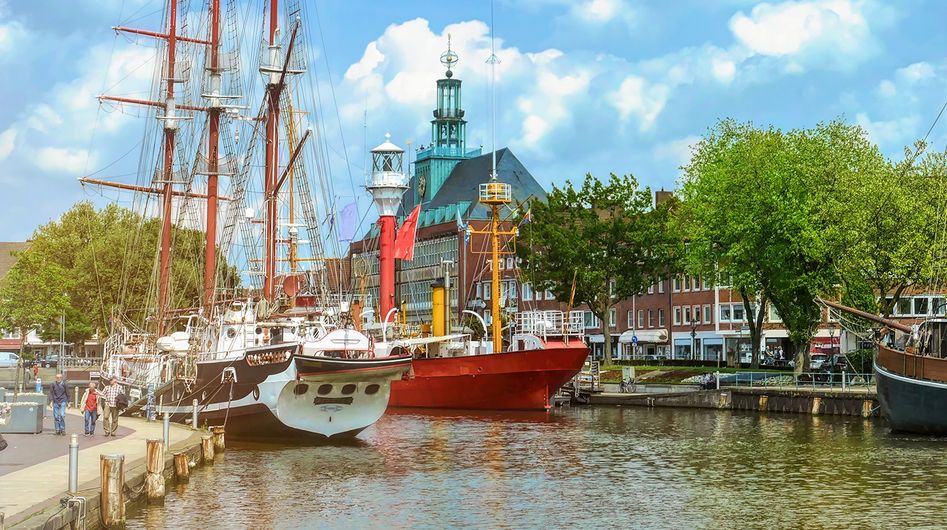 Historische Schiffe im Hafenbecken von Emden, mit dem Rathaus im Hintergrund