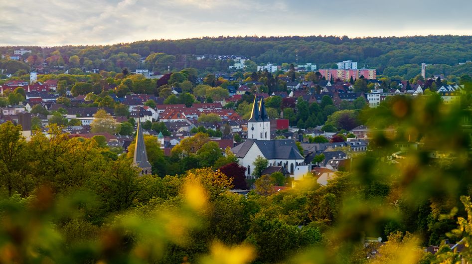 Blick auf Iserlohn durch grün-bunte Laubblätter