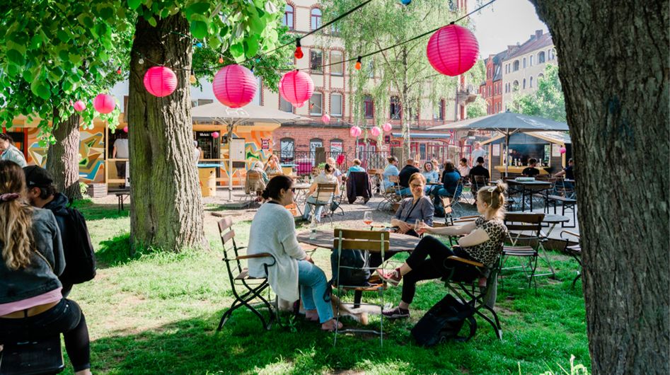 Menschen sitzen draußen in einem Café an einem sonnigen Tag in Kassel.