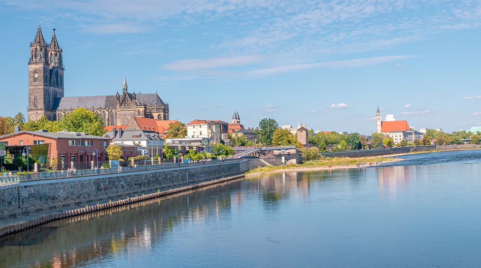 View of a calm river, with Magdeburg Cathedral on the bank