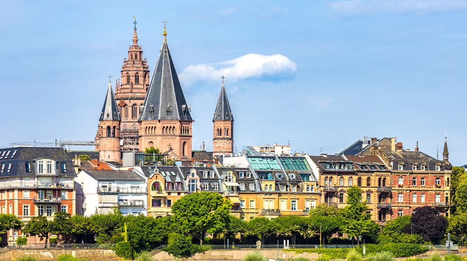 Blick über einen Fluss auf historische Gebäude in Mainz