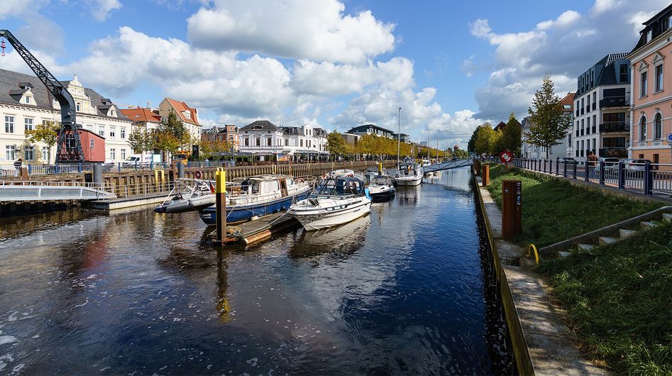 A waterway in Oldenburg with moored boats, buildings on the shore